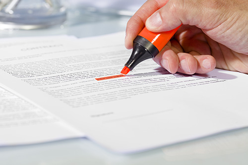 Hand highlighting words in a legal document